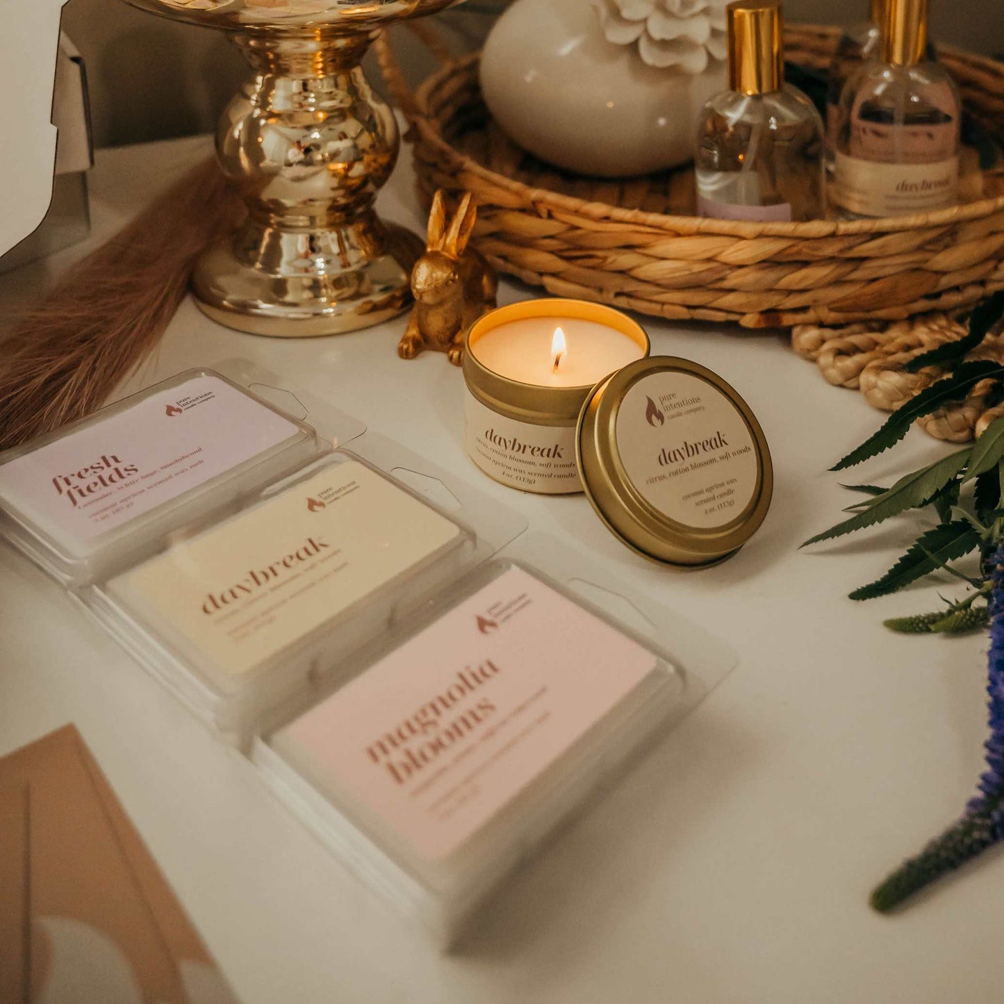 Tabletop display with candles, soaps, and decorative items on a neutral background