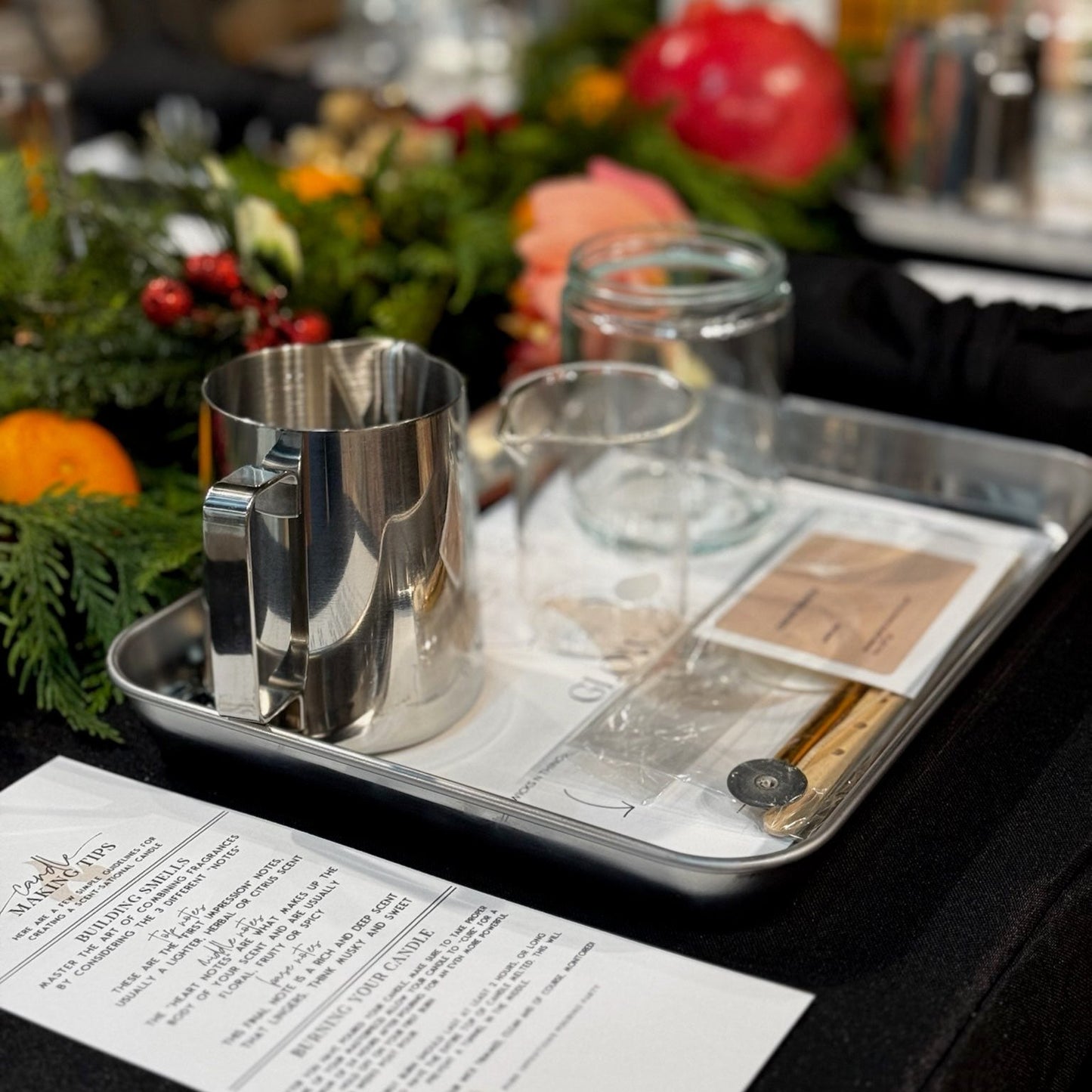 An inviting setup of candle-making materials, including jars, wicks, fragrance oils, and pouring equipment, ready for guests.