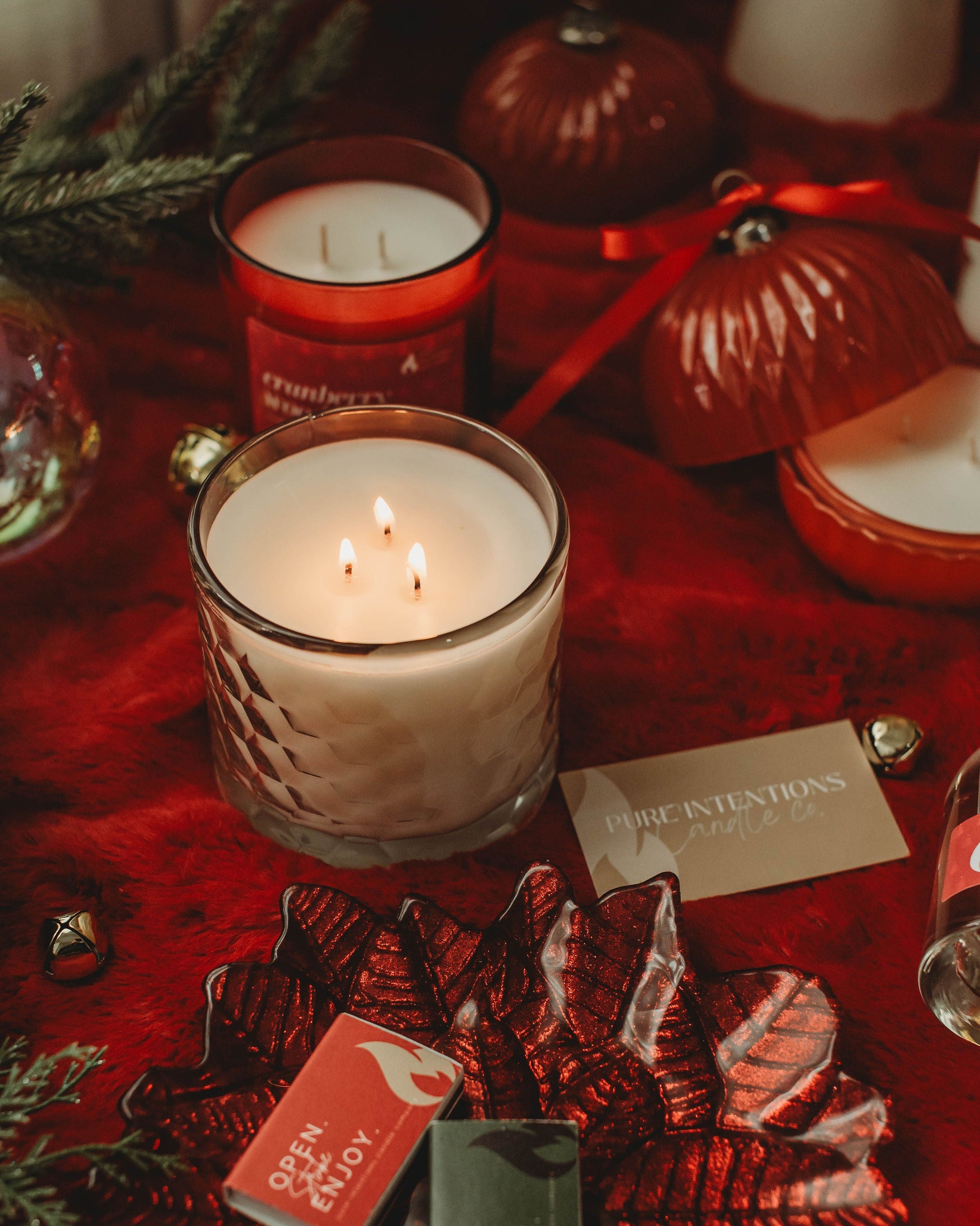 Candlelit scene with red ornaments and matches on a red surface