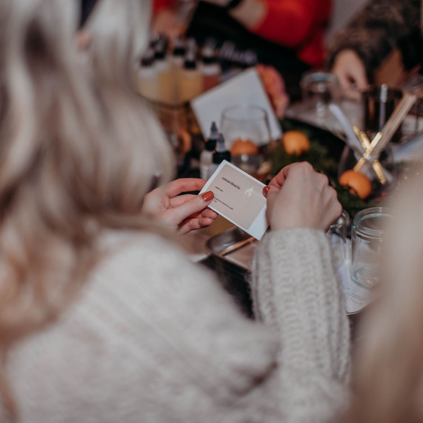 Close-up of a guest designing a custom label for their handcrafted candle, adding a personal touch.